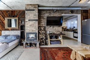 a living room with a stone fireplace and a tv at Villa Ligęzówka in Chyrowa