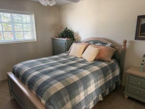 a bedroom with a bed with a plaid blanket at Casa Stu Playa de Oro Rental in San Felipe