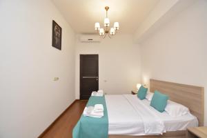a bedroom with a large bed with blue pillows at Apartments by MR Yeravan in the city centre in Yerevan