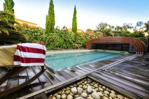 a swimming pool with a towel on a bench at La Villa ioanes in Port-Saint-Louis-du-Rhône