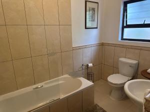 a bathroom with a tub and a toilet and a sink at 45 on Mendelssohn in Johannesburg