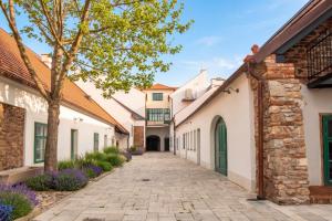 a street with white buildings and purple flowers at Boutique Hotel H23 in Pezinok
