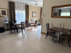 a dining room with tables and chairs and a mirror at 45 on Mendelssohn in Johannesburg