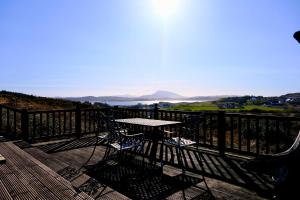 a table and chairs on a balcony with a view at 4 Bedroom House By Travel Lets Holiday Homes Downings With Atlantic View in Downings