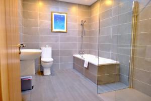 a bathroom with a sink and a toilet and a shower at 4 Bedroom House By Travel Lets Holiday Homes Downings With Atlantic View in Downings +32 photos