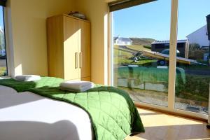 two beds in a room with a large window at 4 Bedroom House By Travel Lets Holiday Homes Downings With Atlantic View in Downings