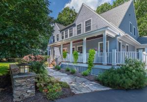 a blue house with a white fence at Mystic Landing in Kennebunk
