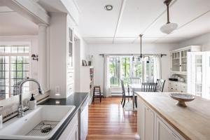a kitchen with white cabinets and a table with chairs at Mystic Landing in Kennebunk