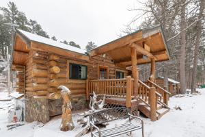 a log cabin in the woods in the snow at Pinecrest Cabin- Serene Black Hills Getaway in Rapid City