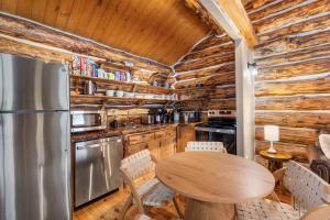 a kitchen with a table and a refrigerator at Pinecrest Cabin- Serene Black Hills Getaway in Rapid City
