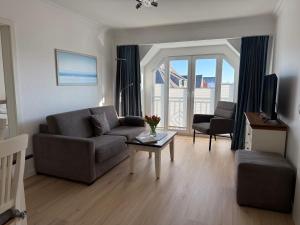a living room with a couch and a table at Appartementhaus Hoppe in Sylt