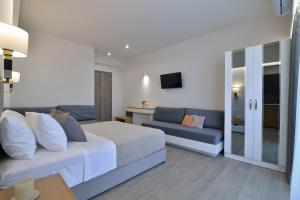 a hotel room with a bed and a couch at Olympus Diamond studios in Olympic Beach