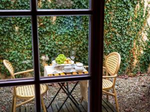 ein Tisch mit einer Obstschale darauf und zwei Stühlen in der Unterkunft Hotel Maltański in Krakau + 30 Fotos