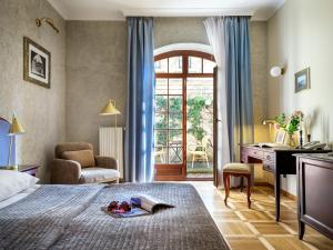 ein Hotelzimmer mit Bett, Schreibtisch und Fenster in der Unterkunft Hotel Maltański in Krakau