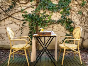 ein Tisch und zwei Stühle und ein Tisch und eine Wand in der Unterkunft Hotel Maltański in Krakau