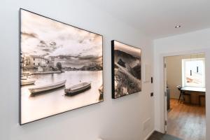 two paintings hanging on a wall in a room at DN ART BLEVIO - Romantic Lake Como Apartment with Indoor Jacuzzi - 5 guests in Blevio