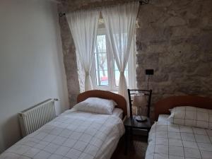 a bedroom with two beds in front of a window at Apartments Jerko in Primošten