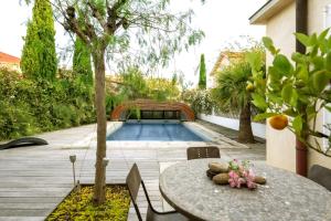 a swimming pool in a yard with a table and a table at La Villa ioanes in Port-Saint-Louis-du-Rhône +28 photos