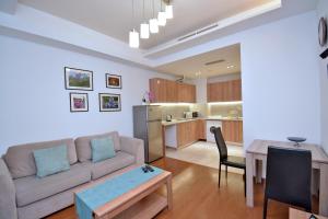 a living room with a couch and a table and a kitchen at Apartments by MR Yeravan in the city centre in Yerevan