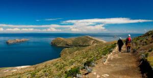 two people walking down a path near the water at Palacio del Inca Lodge Isla del Sol in Comunidad Yumani +9 photos
