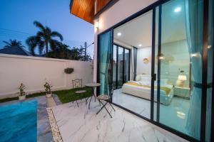 a bedroom with a bed and a pool in a house at Yuan Villa VIP in Rawai Beach