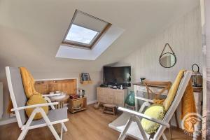 a living room with chairs and a tv and a skylight at L'araukaria in Tressignaux