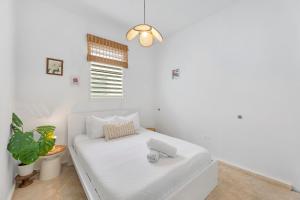 a white couch in a white room with a plant at Boho Oasis by the Beach in San Juan