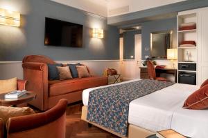 a hotel room with a bed and a couch at Rivoli Boutique Hotel in Florence