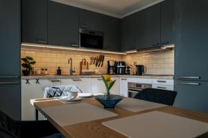a kitchen with a wooden table and black cabinets at Cyklo Apartmán Třeboň in Třeboň