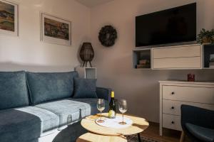 a living room with a couch and a table with wine glasses at Cyklo Apartmán Třeboň in Třeboň