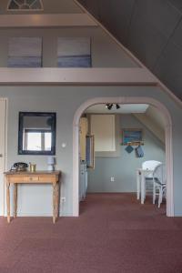 an archway in a room with a table and a kitchen at Achterom in Biggekerke