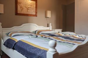 a white bed with a colorful blanket on it at Achterom in Biggekerke