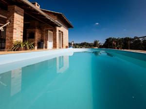 a large blue swimming pool next to a house at Chalé 1 Refúgio do Sol Piscina com Vista para Montanas in Socorro +40 photos