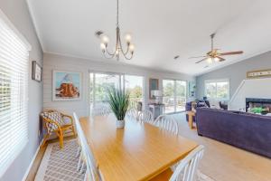 a dining room and living room with a table and chairs at Dock Holiday OBX Village in Duck