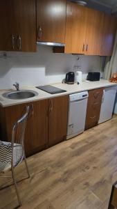 a kitchen with wooden cabinets and a sink and a chair at Apartament Riva in Rowy +3 photos