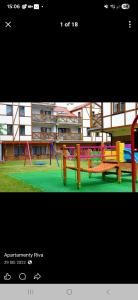 a picture of a playground with benches and a building at Apartament Riva in Rowy