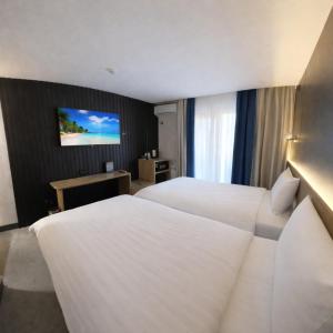 a hotel room with two beds and a flat screen tv at Avenue Park Hotel in Yusufkhona +25 photos