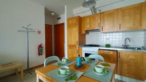 a kitchen with a table and chairs and a sink at TRILOCALE DIRETTAMENTE SUL MARE- cod 511 in Porto Recanati