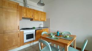a kitchen with a wooden table with chairs and a stove at TRILOCALE DIRETTAMENTE SUL MARE- cod 511 in Porto Recanati