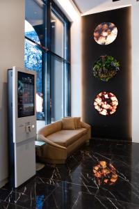 a lobby with a ticket machine and a couch at Luwian Athens Boutique Hotel in Athens
