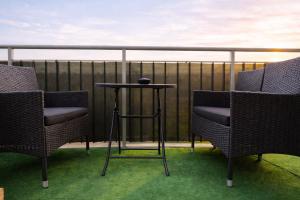 two chairs and a table on a balcony at Modern 2-Room Apartment with Large Balcony & Private Parking in Gdańsk