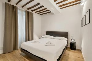 a white bedroom with a large bed with white sheets at Il Fiore del Prione in La Spezia