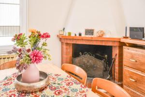 a dining room table with a vase of flowers on it at Da Nonna Mena in Fossacesia