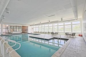 a large swimming pool with tables and chairs in a building at Dock Holiday OBX Village in Duck