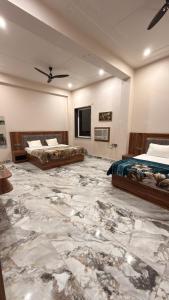 two beds in a room with a marble floor at Hotel Tara Grand in Mathura +19 photos