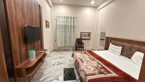 a hotel room with a bed and a desk at Hotel Tara Grand in Mathura