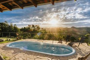 a hot tub on a patio with a view of the mountains at Chalé 1 Refúgio do Sol Piscina com Vista para Montanas in Socorro
