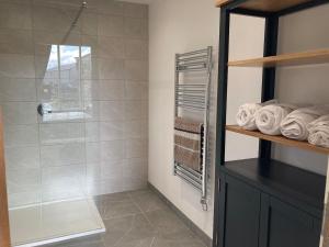 a bathroom with a shower and some towels at Moorlands Farm Holidays in Keighley +55 photos