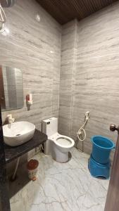a bathroom with a toilet and a sink at Hotel Tara Grand in Mathura