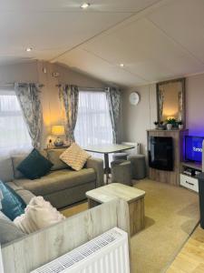 a living room with a couch and a table at Calypso Hot Tub Breaks Tattershall Lakes Pet Friendly in Tattershall